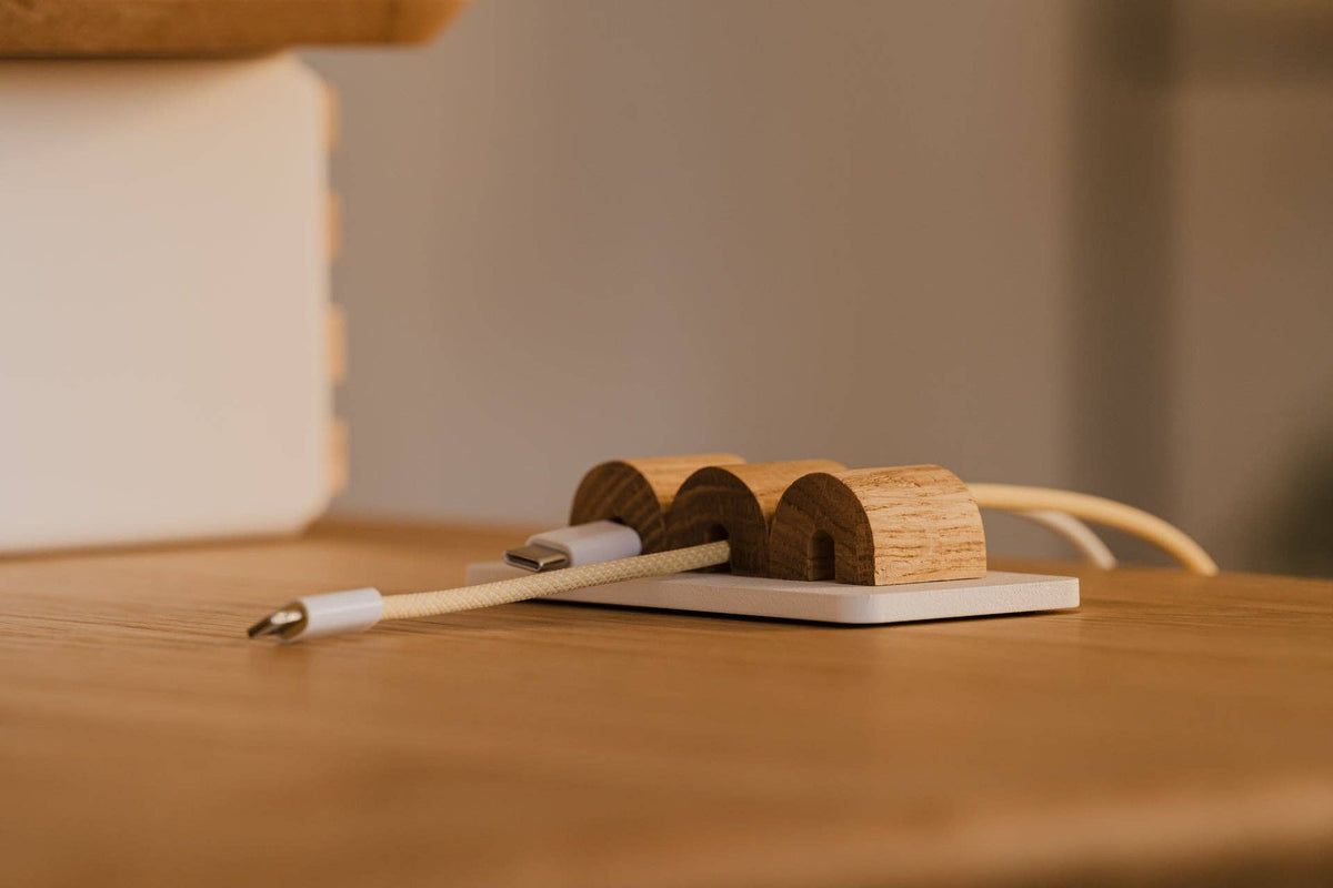 Oakywood kabel organizer met laadkabels op een opgeruimd bureau
